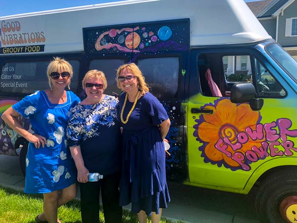 Three women smiling in front of gelato truck at grad party