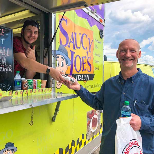 Food Truck Employee Smiling while Serving Happy Guest