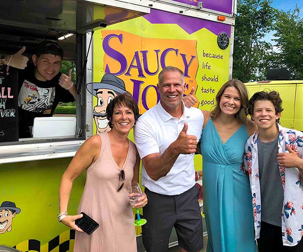 Family Smiling with Graduate in front of Food Truck at Grad Party