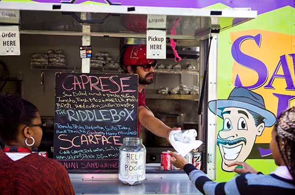 Metro Detroit's Best Food Trucks | Saucy Joe's Italian - Handing-out-sandwich-Saucy-Joe's-Italian-Food-Truck