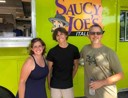Family in front of Saucy Joe's Food Truck at Grad Party