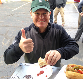 Dave smiling with a thumbs up while eating meatball sandwich