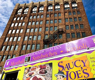 Saucy Joe's Food Truck parked in front on Detroit office building